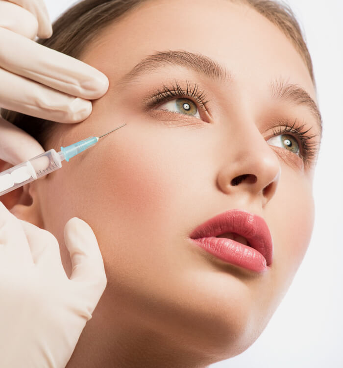 Image of a model being injected with a syringe on her face