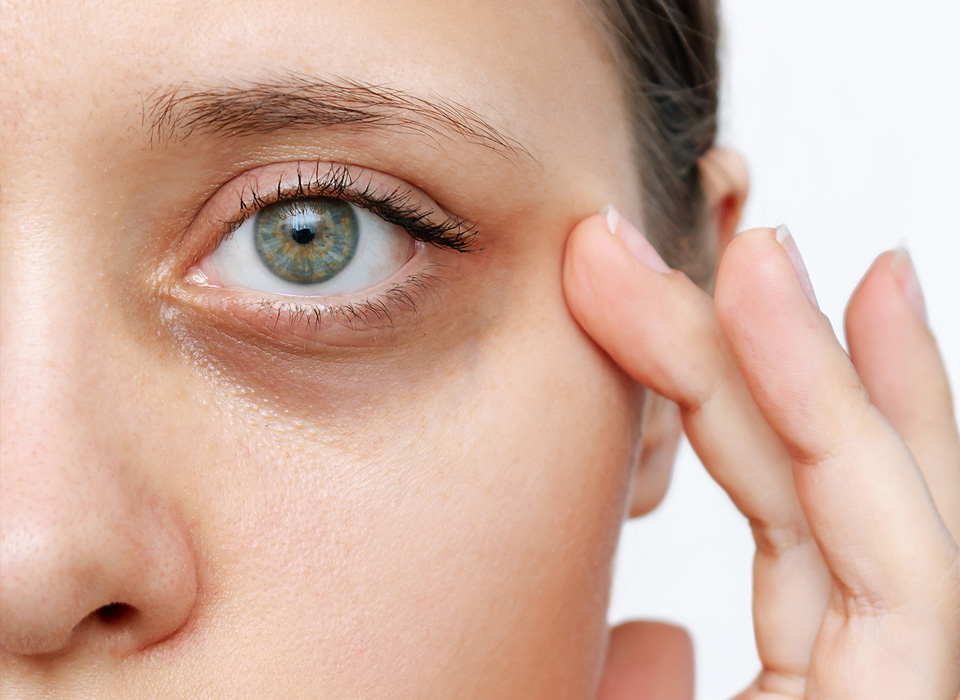 Front view of single eye of an woman with her finger touching side of the eye