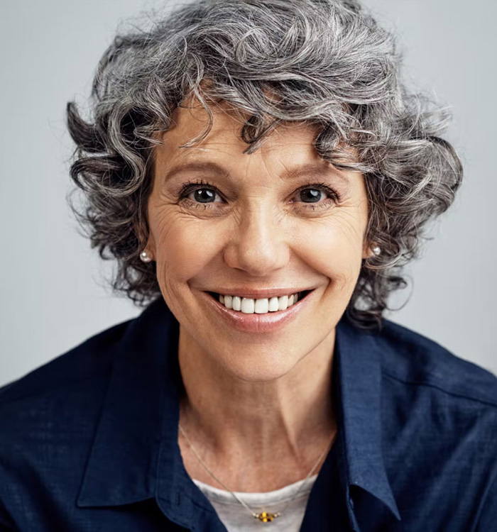 A smiling older woman with blue shirt