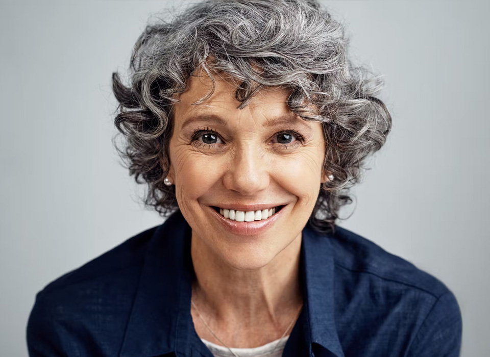 A smiling older woman with blue shirt