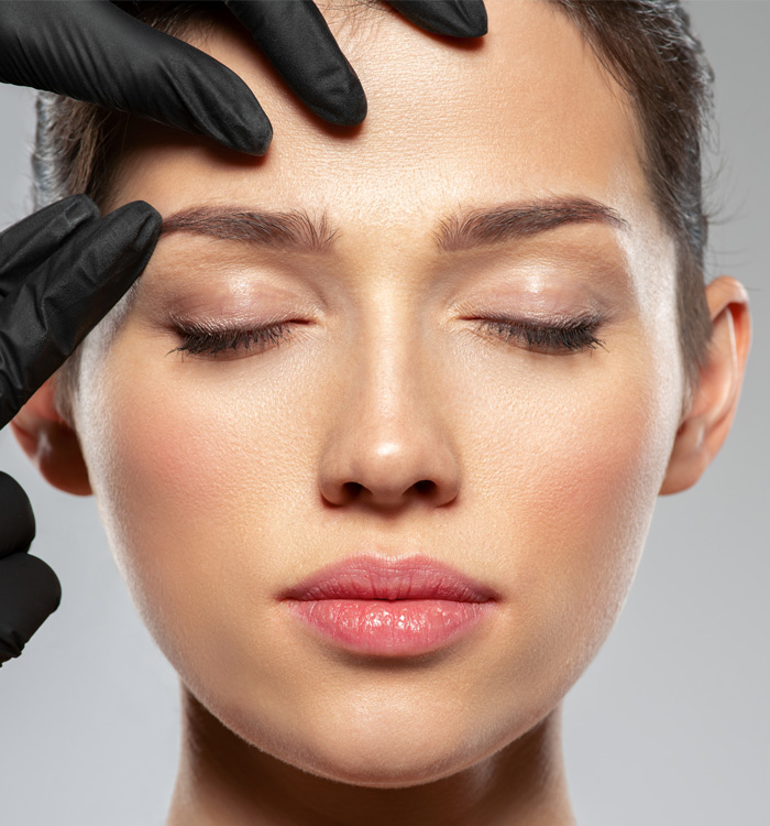 As asian girl is being checked her eye brow area with doctor's hands