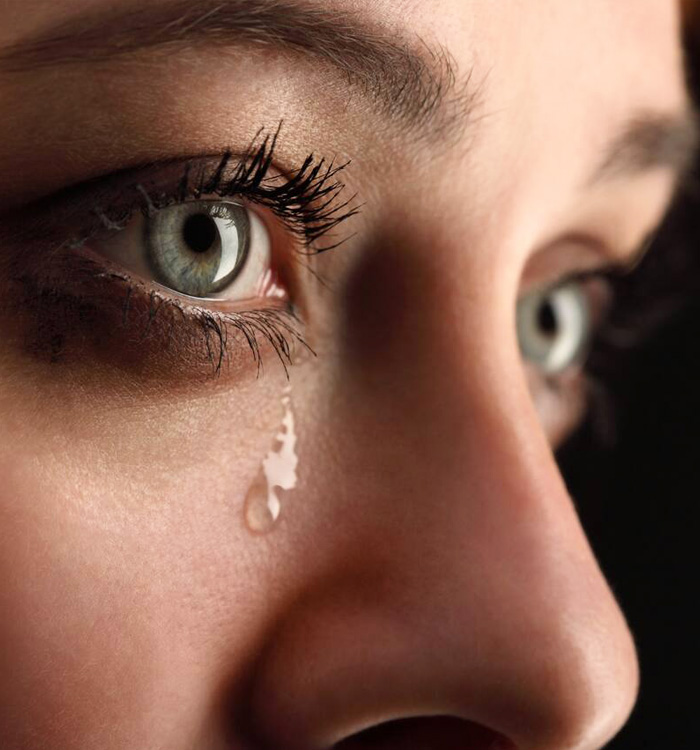 Side view of an woman with tear from her eye